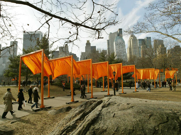 An image of The Gates. Several orange gateways are along a trail, which people pass under.