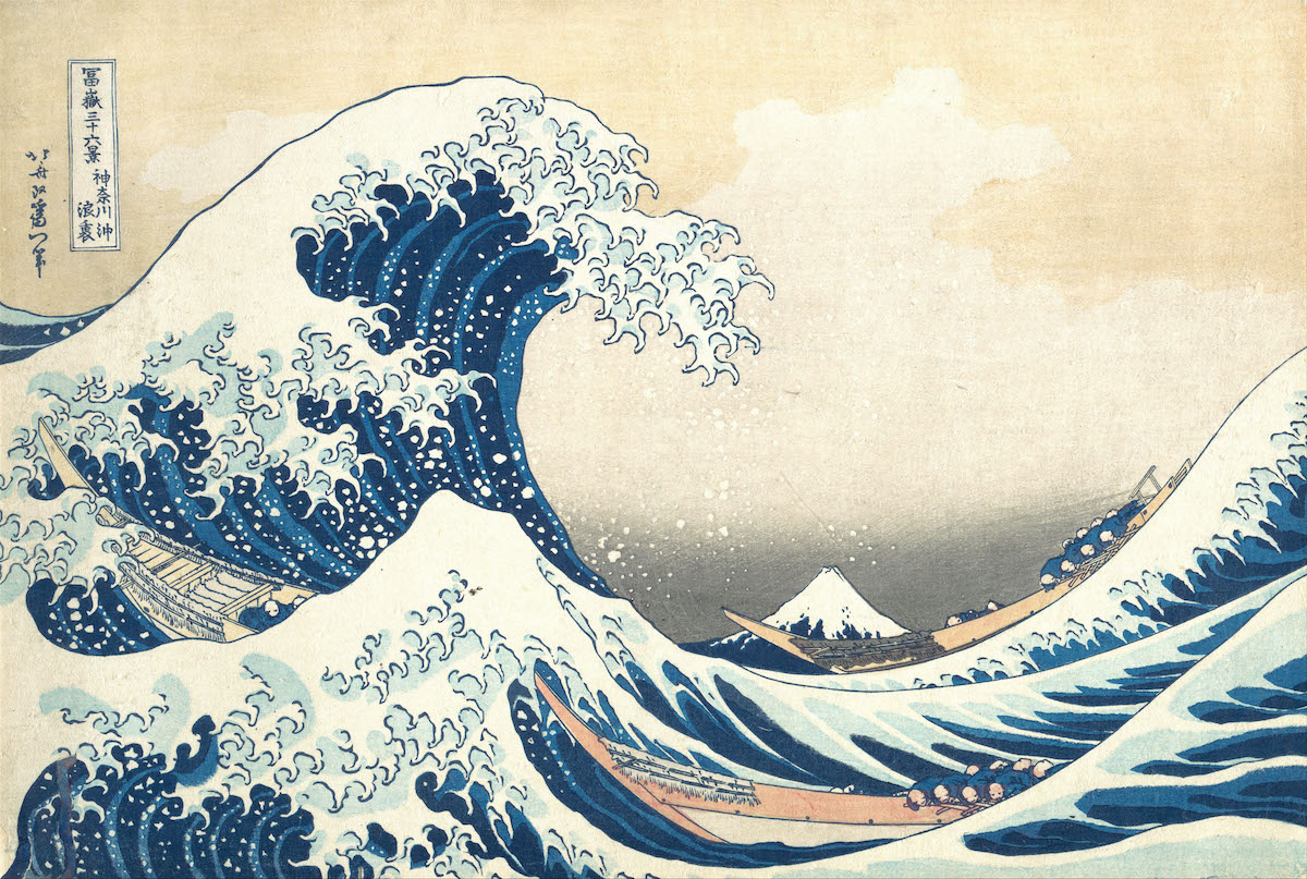 A large blue and white wave dominates the left side of the painting. It is about to overtake two fishing boats.