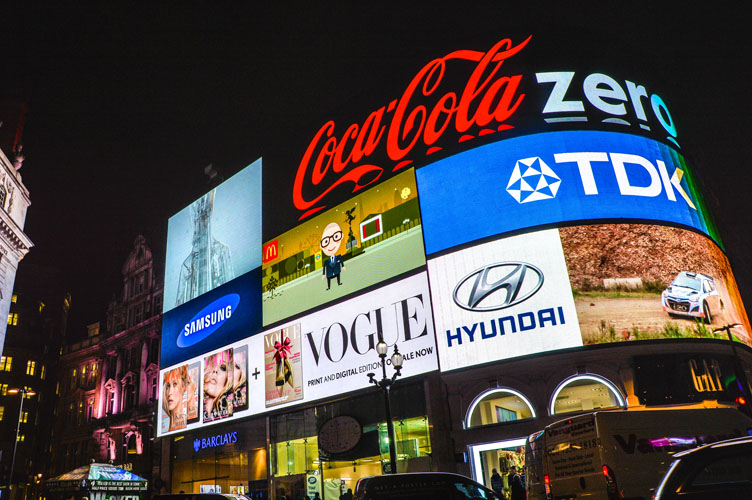 Popular brands such as Coca-Cola, Vogue, Hyundai, and TDK are displayed in an electronic billboard.