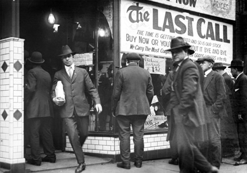 People lining up to buy alcohol from a store.