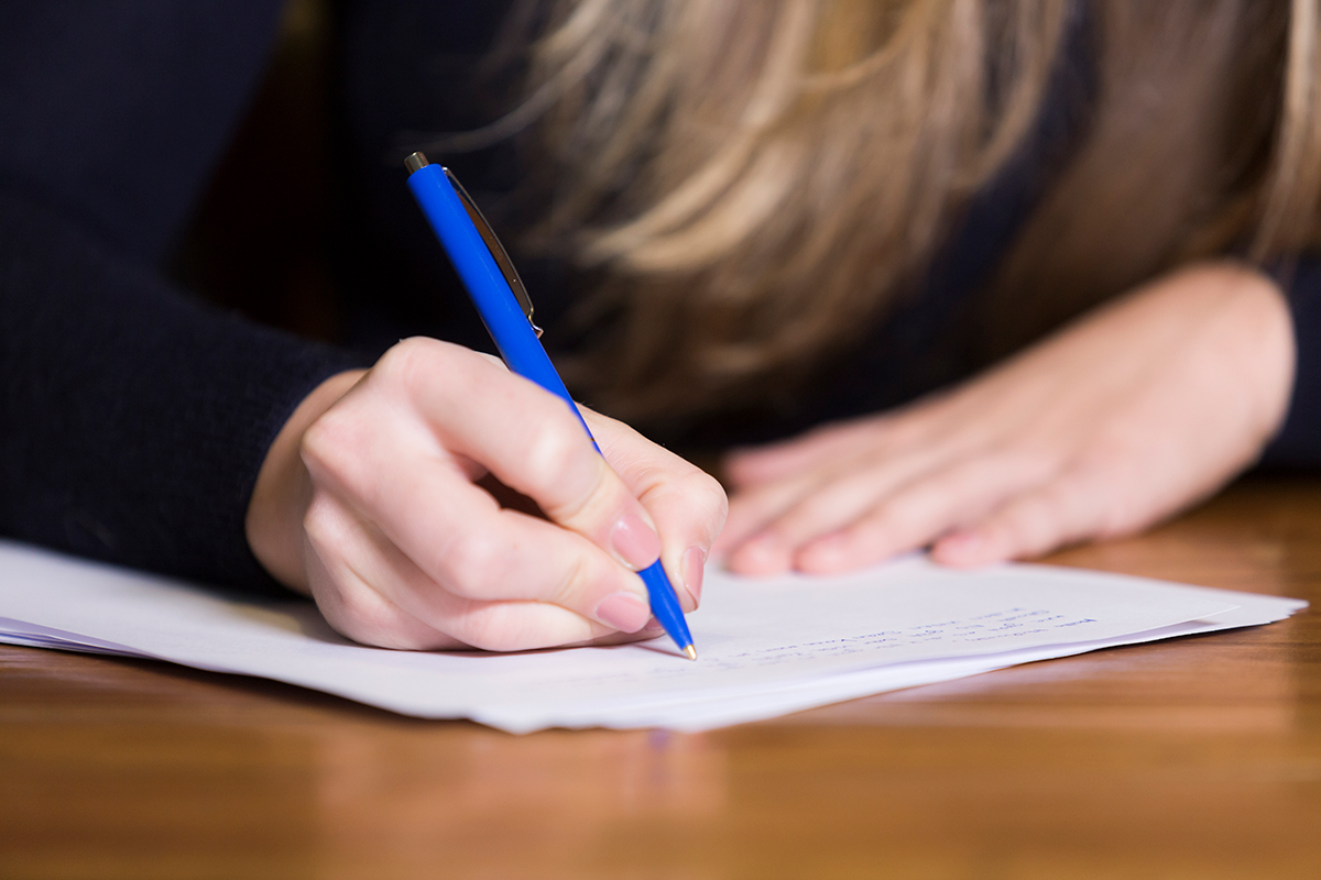 A person writing on a piece of paper.