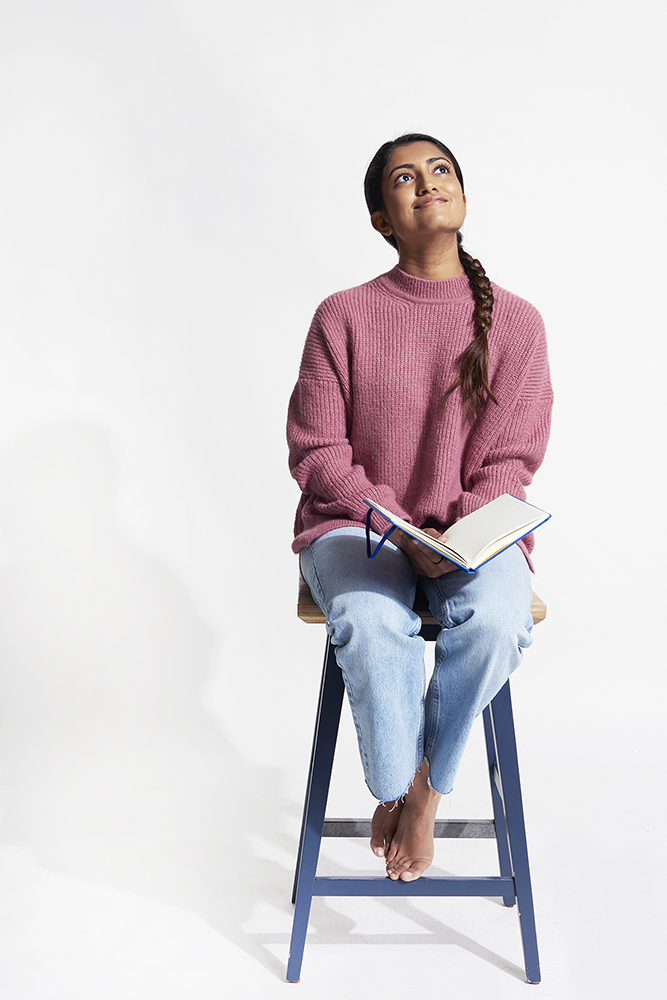 Person, deep in thought, sitting on a ladder with a book