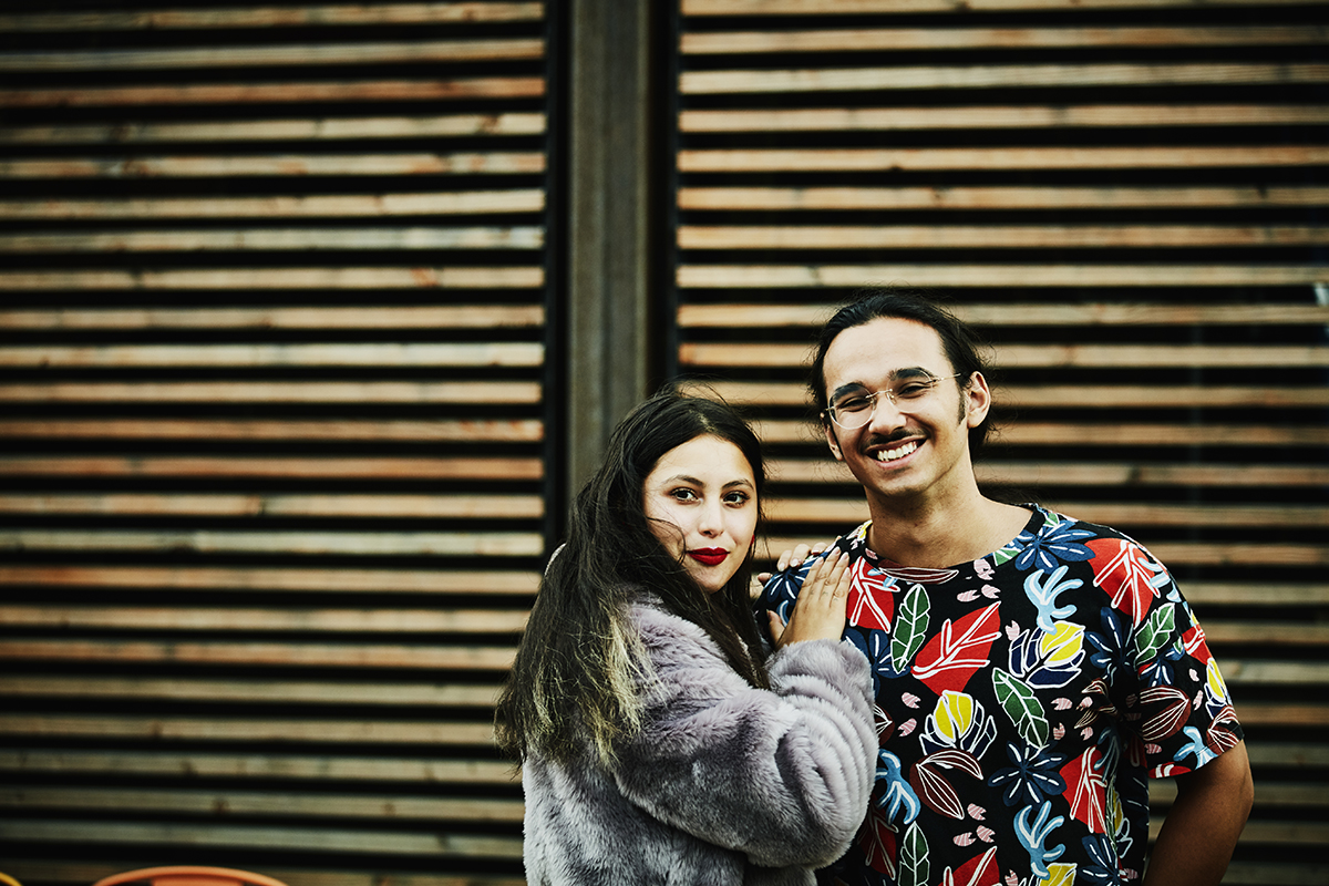 A couple smiling and standing close together.