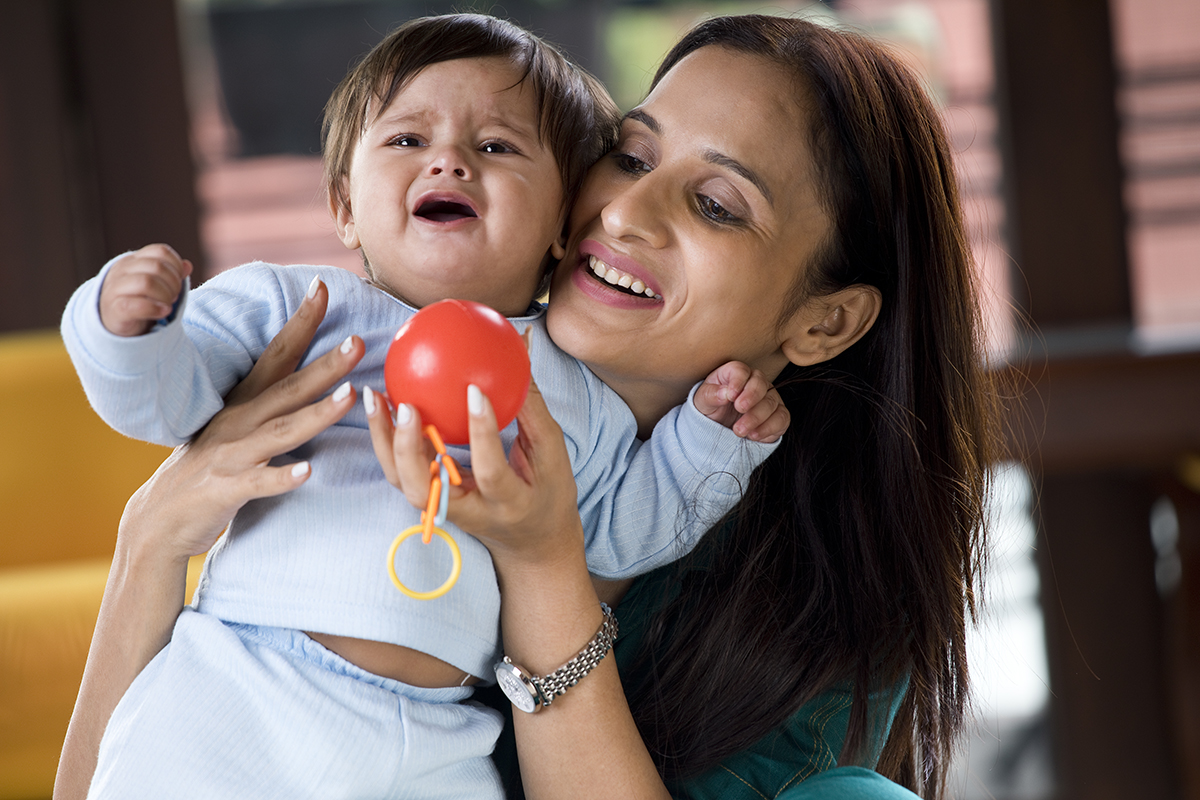 Parent playing with crying baby