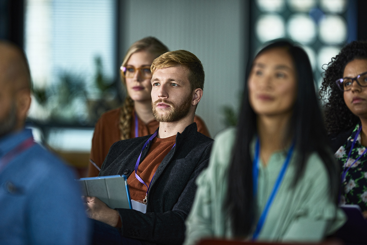 Students in a classroom, listening to the instructor