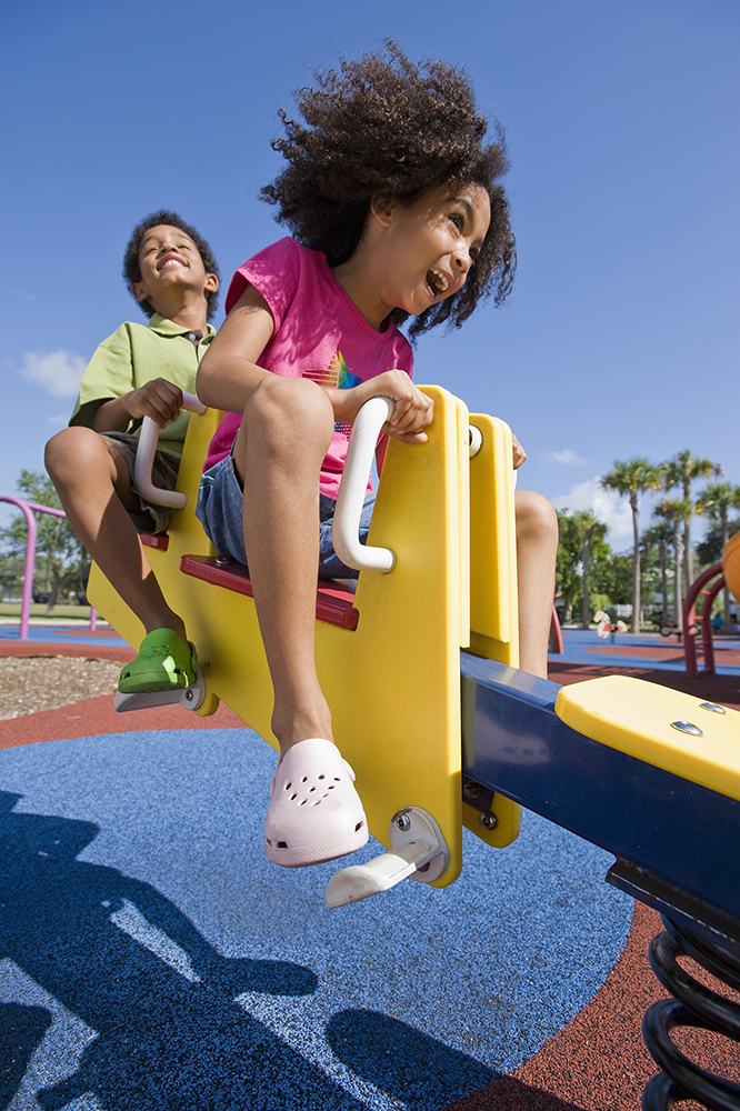 Two children playing on a see-saw