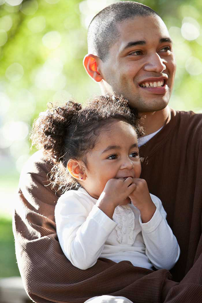 Adult holding young child in their arms.