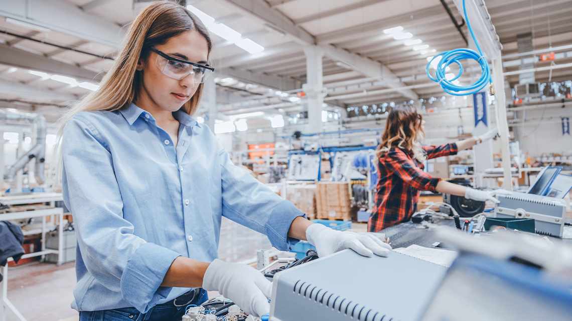 Young woman working on the production line of an electronics factory.