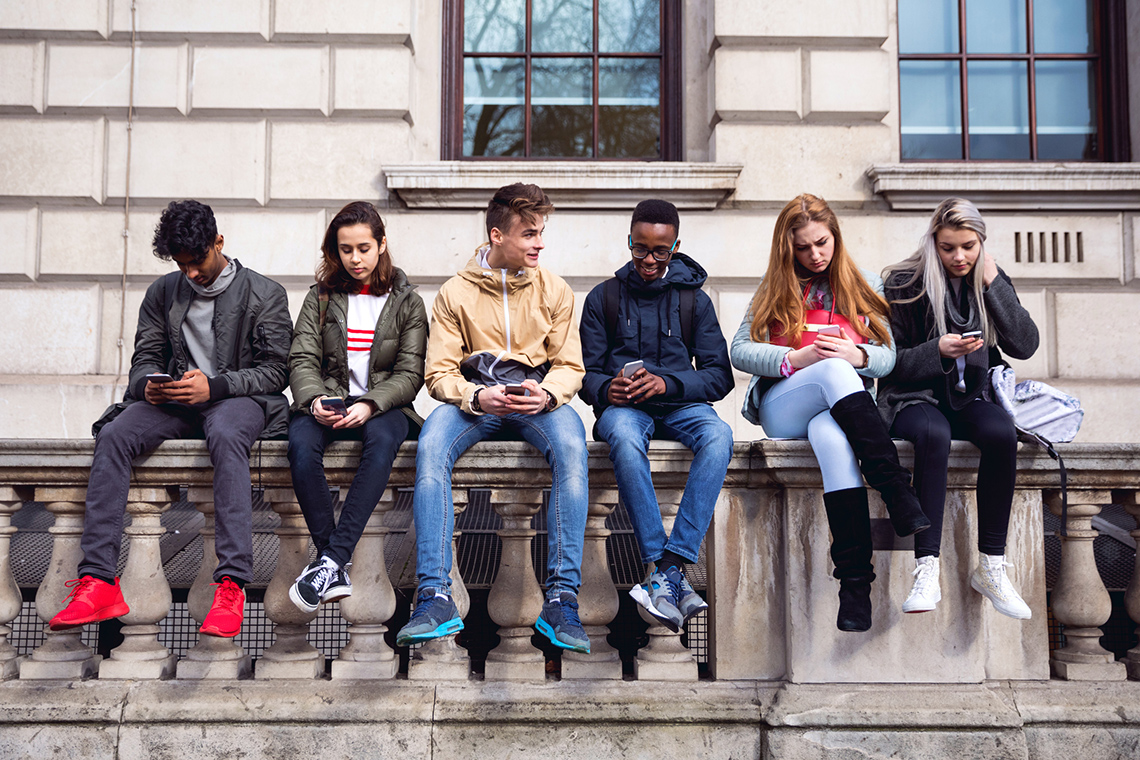 A group of teenagers using their smartphones
