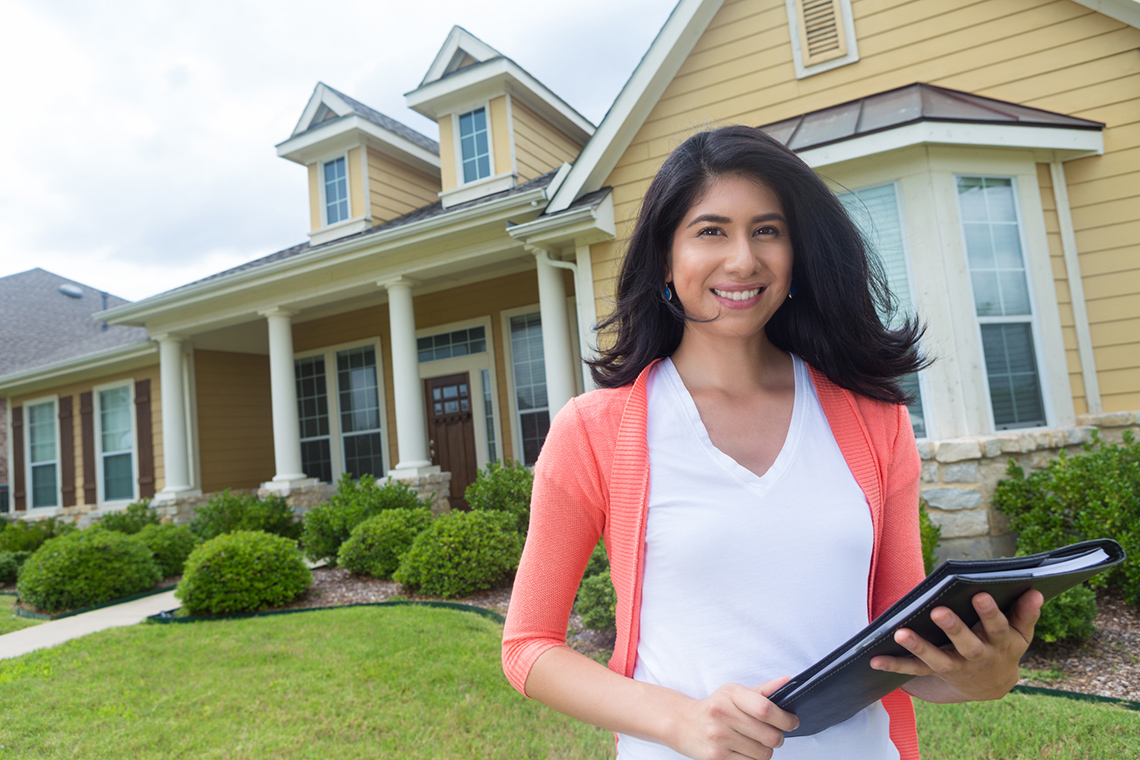 A real estate agent in front of a home
