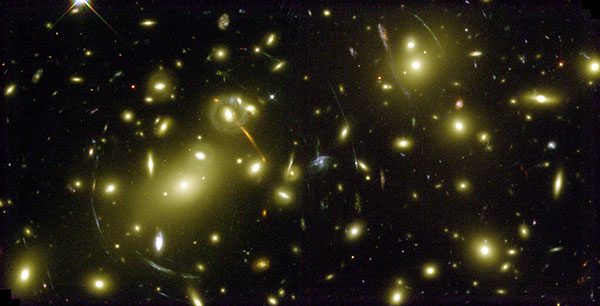 Distant galaxies behind Abell 2218 are distorted by its gravity and so look like streaks or smears