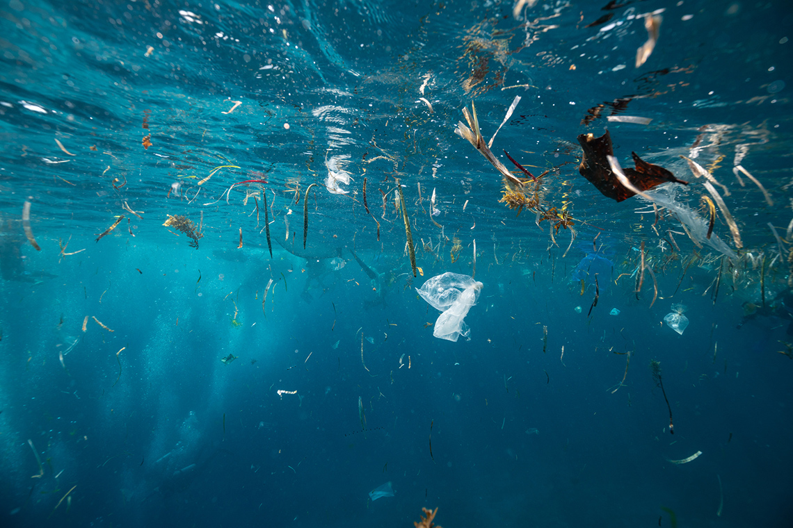 Underwater perspective of plastic garbage and other contaminants in a body of water.