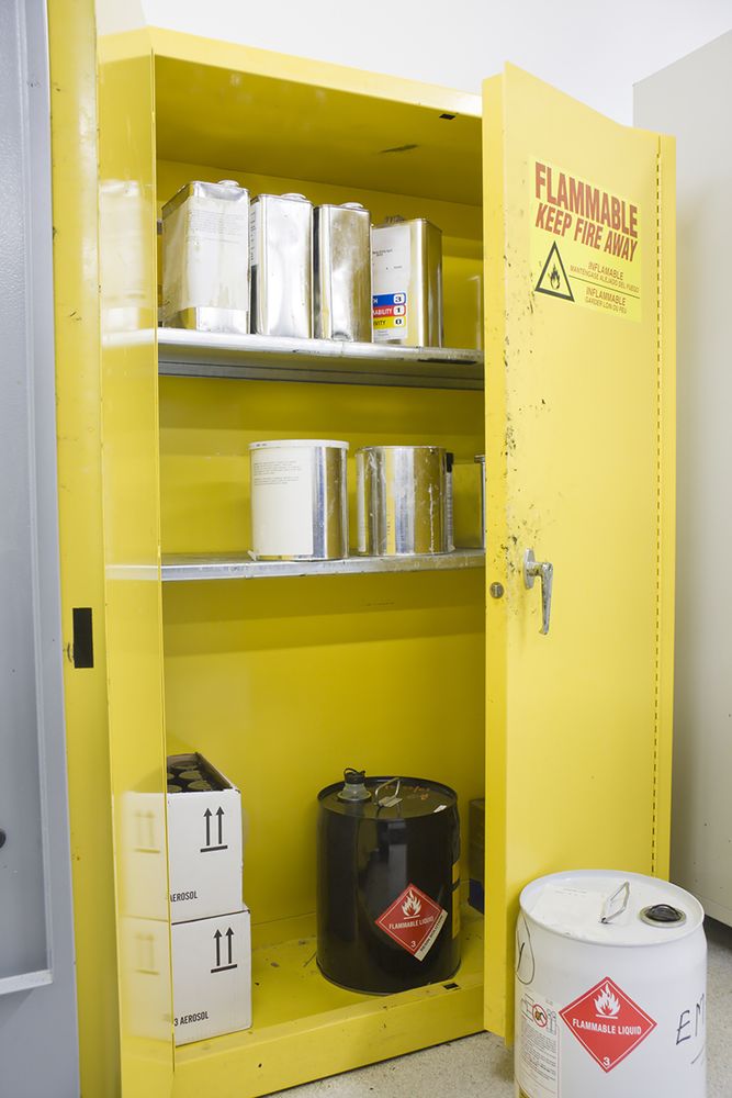 An open locker with chemical hazards inside.